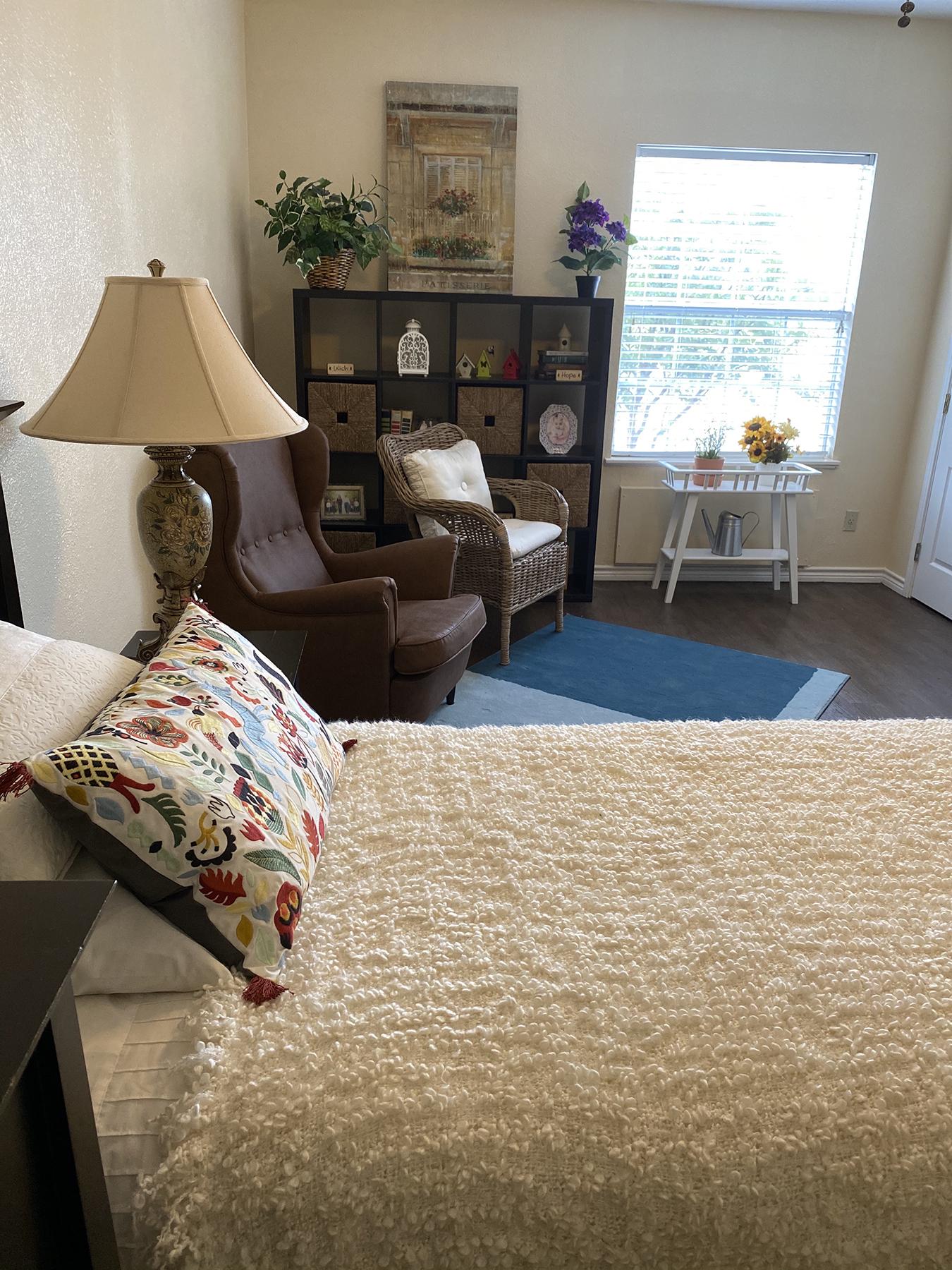 Assisted living apartment with bed, sitting area, and window light